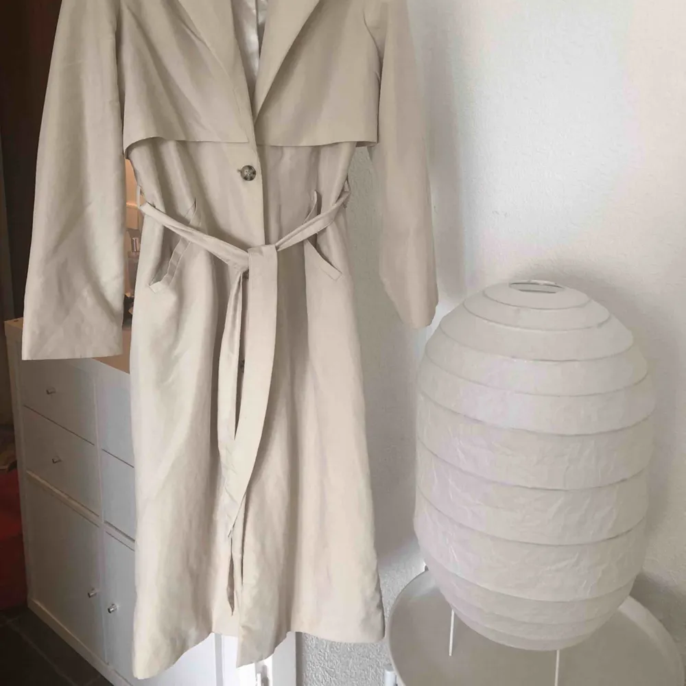 Ljusbeige kappa/trenchcoat ifrån Monki. Nypris låg runt 700-800! Kappan har nästan inte använts alls så den är i finfint skick! En liten fläck på kragen som säkert kan tvättas bort!. Jackor.