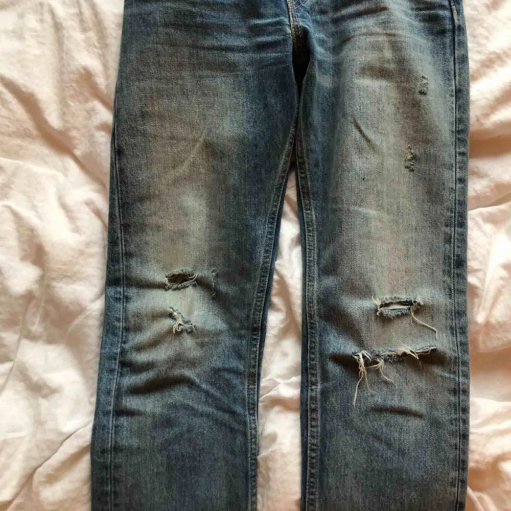 Ett par otroligt fina jeans från Levi’s med slitningar på knäna. Tyvärr en liten liten blå fläck på vänster lår, annars jättebra skick!! Säljer pga för små</3 frakt tillkommer!. Jeans & Byxor.