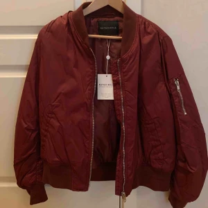  - Vinröd bomberjacka, (köpt för 399kr) Aldrig använt (prislapp kvar) Storlek 42, passar även någon som har 40