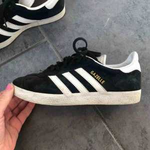  - Svarta adidas gazelle med vita ränder. Skorna är använda men inte jättemycket så inga större slutningaskador på dom. Köparen står för frakten🥰