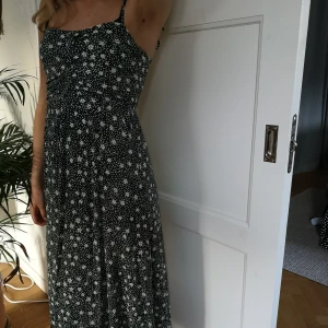 Fin blommig sommarklänning - Fin helt oanvänd sommarklänning, söta vita blommar mot grön bakgrund. Även fin med en oversized college tröja över eller till jeansjackan. Frakt står köparen för. 