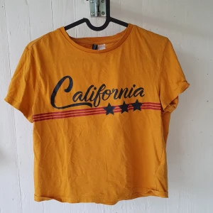 Senapsgul T-shirt  - 🌼super söt senapsgul T-shirt med snygg logga på. Perfekt till sommaren. Säljer pga att den tyvärr inte används längre Frakt ingår i priset🌼
