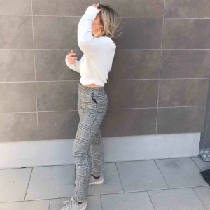 Grå kostymbyxor - Ett par gråa rutiga kostymbyxor ifrån NA-KD. Storlek 34. Knappen har lossnat som man stänger med ( sista bilden ) men det finns fortfarande en metallhake man stänger med. Säljer då de har blivit för små. Köparen står för frakten 🤍