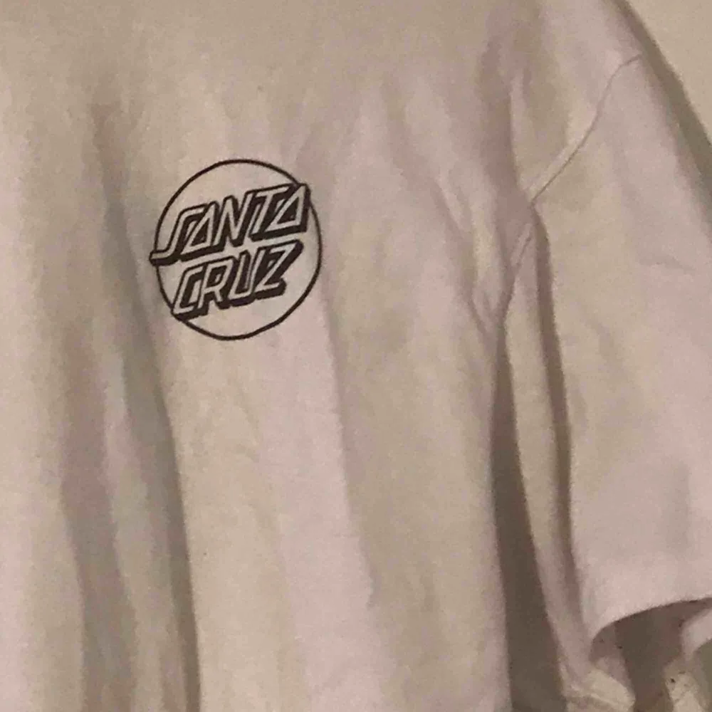 Säljer min vita Santa Cruz tisha, med coolt tryck på baksidan! Köparen står för frakt<3. T-shirts.