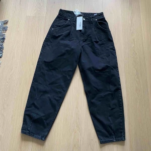  - Svarta högmidjade jeans. Aldrig använda. Frakt ingår inte i priset.