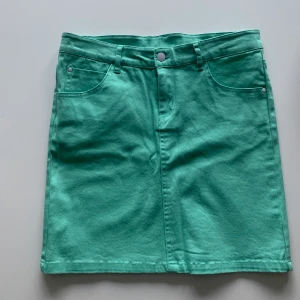 En mintgröna jeanskjol  - Helt ny kjol i en fin klar färg med simpla detaljer på fickorna. Den är i storlek 34 & säljs på grund av att den är för liten för mig😣🦋 frakt tillkommer 