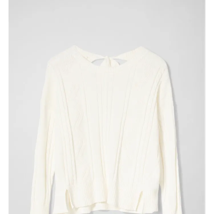 Belina cable sweater är en kabelstickad tröja från Maria Westerlind. Tröjan har en öppning i ryggen som knyts med dekorativa knytband. Oanvänd, prislapp kvar. . Stickat.