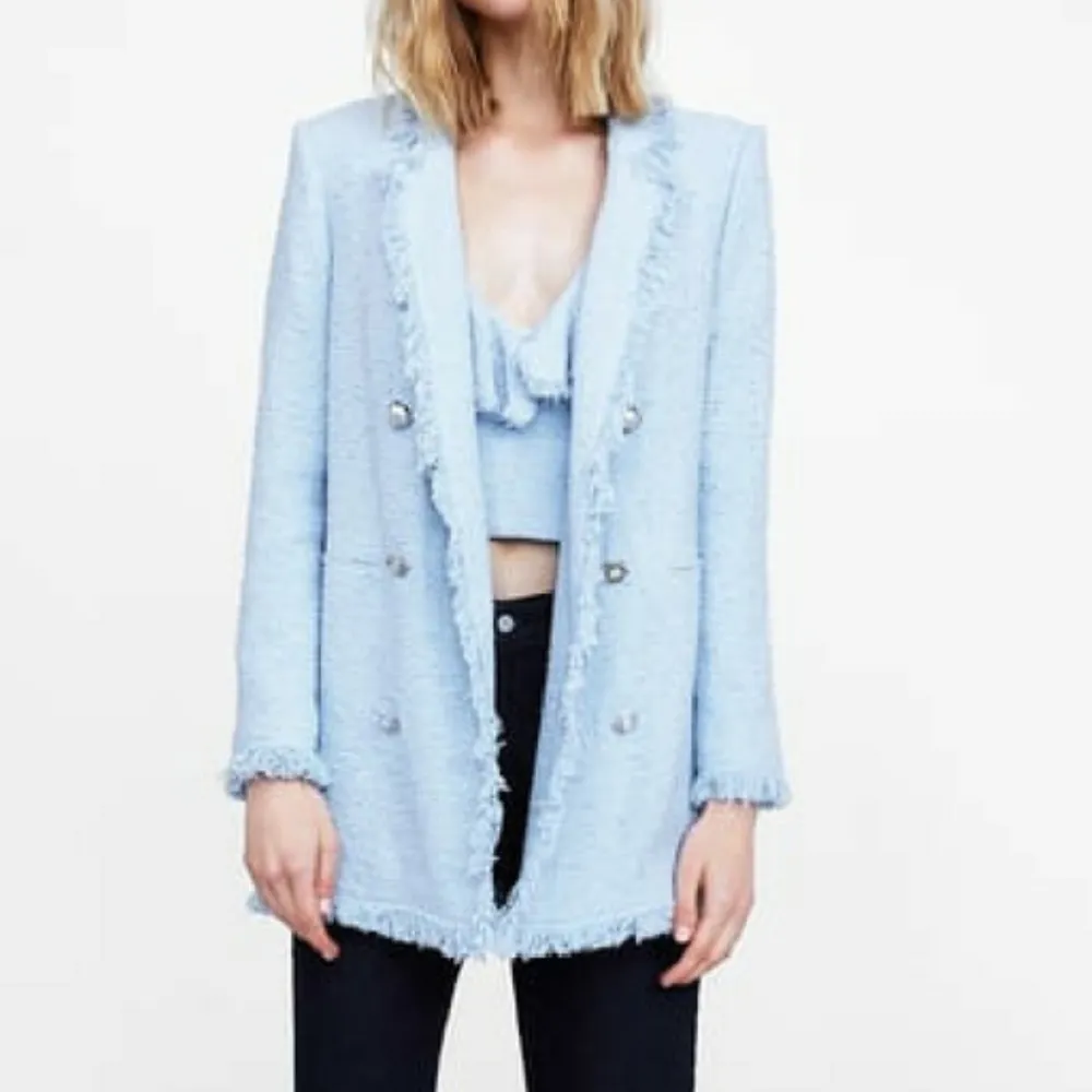 Zara ljusblå tweed-blazer med pärlknappar. Inköpt för 799kr. På bild 3 så finns det mellan bröstet och axeln på höger sida en ljusare färg på tyget, syns inte mycket men vill informera och därav det billiga priset ❤️. Kostymer.