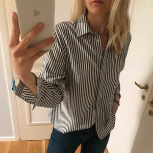  - Grå och vit randig skjorta.