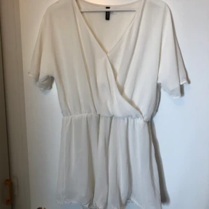 Vit playsuit - Vit playsuit med överdel i omlott och spetsdetaljer i benen. Använd 1 gång, mycket bra skick!