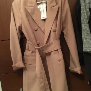 Kavaj  - Snygg lång kavaj, kan användas med eller utan skärp, helt ny prislappen kvar, ord pris 449kr, passar både 36 & 38