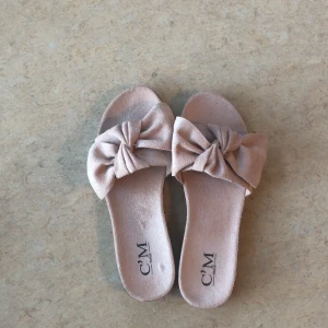 Tofflor med rosett - Oanvända tofflor med rosett på. Små i storleken passar 36 bättre än 37.