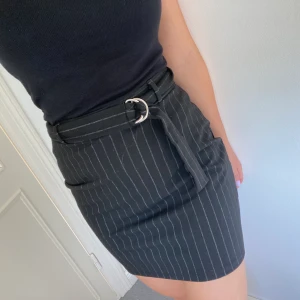 Randig kjol - En kjol i mjukt material med bälte man kan spänna åt. Är marinblå med svagt vita ränder. 100kr inklusive frakt.