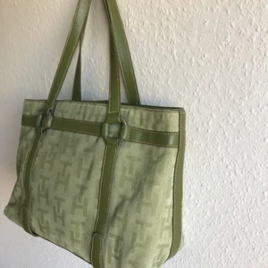 Grön handväska TH - 🍃fake Tommy Hilfiger handväska🍃 35x25x12cm, några småfläckar på framsidan som kan ses på bild 3. pris: 140 inkl frakt med postnords skicka lätt. kontakta mig för fler bilder och med frågor!