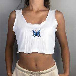 Ett vitt linne med den blå fjäril på från SHEIN! Ej använd, buda i kommentarerna :)