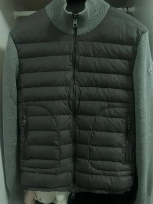 Grå - moncler cardigan  - Säljer min Moncler Maglia Cardigan i en stilren grå färg. Det är den klassiska hybridmodellen med quiltad framsida och stickat material på ärmar och rygg. Tröjan är i bra skick och har använts vid ett antal tillfällen, men är väl omhändertagen. Säljes nu för att göra plats för nytt i garderoben. Passa på att skaffa ett riktigt snyggt och användbart plagg från Moncler!  PRIS KAN DISKUTERAS!