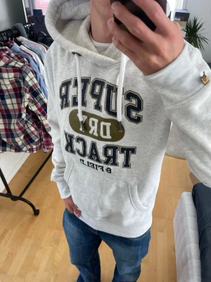 Ljusgrå Vintage 2000s Superdry Hoodie (sällsynt) - Säljer nu denna sjukt snygga Vintage 2000s SuperDry hoodie! Passar till allt och har en perfekt passform. Säljs ej längre i butik och är därav mycket eftertraktad😊 passar S perfekt ! Skriv vid funderingar 🤝