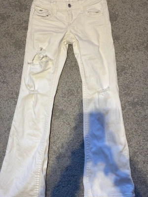 Vita bootcut jeans - Säljer ett par vita bootcut jeans med slitningar på båda benen och snygga detaljer vid fickorna. De är från Gina i storlek 152. Säljer pga de är för små och har används cirka 2 gånger. Skriv för fler bilder eller frågor!