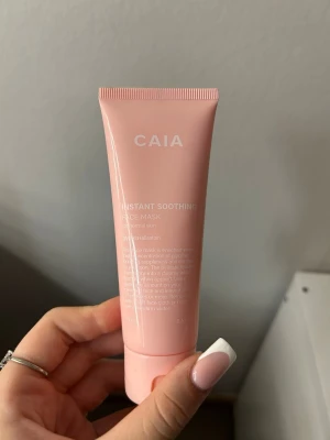 CAIA Instant Soothing Face Mask - Säljer en CAIA Instant Soothing Face Mask i en ljusrosa tub. Ansiktsmasken är framtagen för normal hud och innehåller panthenol och allantoin. Tuben är smidig och lätt att ta med, perfekt för en snabb återfuktning.