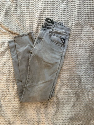 Gråa slim fit jeans från Replay - Snygga gråa slim fit jeans från Replay med klassisk femficksdesign och diskreta sömmar på bakfickorna. Skick 10/10. Replay anbass, 27/32.