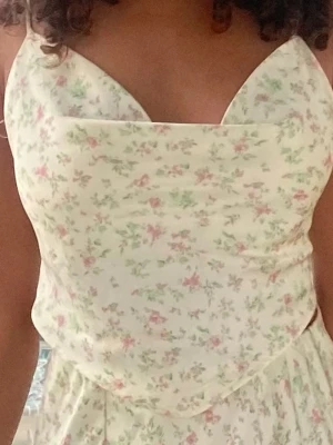Blommig topp med snörning i ryggen - Söt topp från Ginatricot med blommigt mönster. Toppen har tunna axelband och en öppen rygg. I storlek 34.