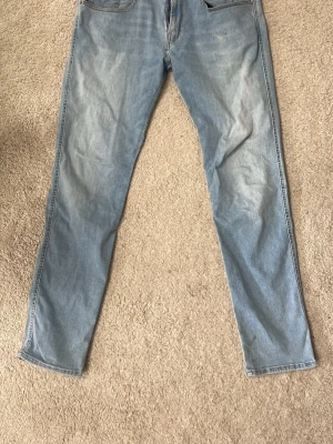 Ljusblå Replay Hyperflex jeans - Säljer ett par ljusblå jeans från Replay Hyperflex med klassisk femficksmodell och raka ben. Jeansen har en snygg tvättad look och är tillverkade i stretchigt material för extra komfort. Perfekta för en avslappnad och trendig stil.