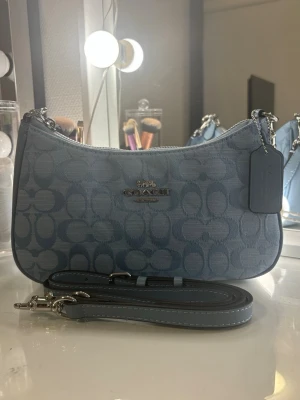 Ljusblå coach väska - Säljer min Coach Tabby Shoulder Bag i en ljusblå/isblå färg. Väskan är helt ny och i perfekt skick utan några repor, märken eller slitage. Väskan har en justerbar axelrem och kan bäras på flera olika sätt. En stilren och tidlös modell som passar till både vardag och finare tillfällen. Kan gå ner i pris