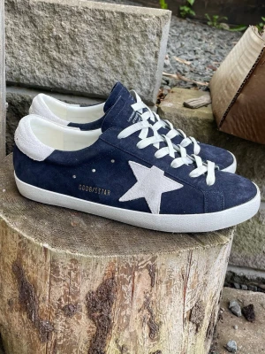 Golden goose skor - Riktigt snygga golden goose superstar sneakers, varsamt använda, knappt slitna. Säljes till ett mycket bra pris. Marinblå med snygga diskreta ”slitningar”. Storlek 44. Box + tillbehör medföljer. Skriv vid funderingar och fler bilder. Först till kvarn! Skickar snabbt!