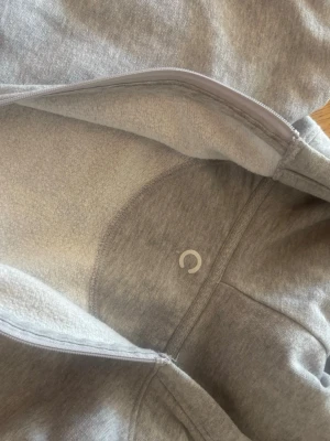 Grå zip-hoodie från Cubus - Snygg grå hoodie med dragkedja från Cubus. Klassisk modell med huva och två fickor framtill. Mjuk insida i fleece och diskret logga i nacken. Perfekt för en chill och avslappnad stil.