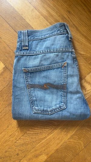 Nudie Jeans Grim Tim - Ett par ljusblåa nudie jeans i modellen ”grim tim” och storleken ”W27 L32” Skriv vid minsta fråga!