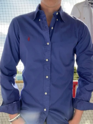 Blå skjorta från Ralph Lauren - Snygg blå skjorta från Ralph Lauren i slim fit-modell. Skjortan är perfekt sommarn. Priset går att diskutera skicka gärna bud