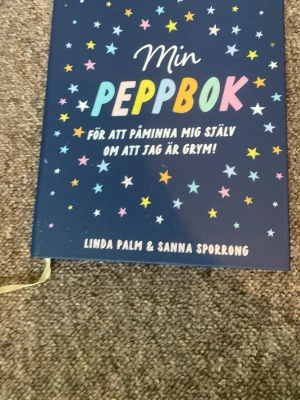 Min Peppbok av Palm & Sporrong - En peppande och inspirerande bok med mörkblått omslag, färgglada stjärnor och text i olika färger. Perfekt för att boosta självkänslan och påminna sig själv om att man är grym. Skriven av Linda Palm och Sanna Sporrong.              Har skrivit i den för flera år sedan men bara på några sidor! Tar emot vilket bud som helst då jag snart flyttar!