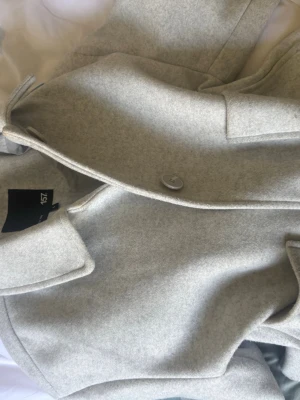 Ljusgrå/vit kappa från 157 - Snygg ljusgrå/vit kappa från 157 i storlek S. Klassisk rak modell med krage och knäppning framtill. Tillverkad i ett mjukt och stilrent material som passar perfekt till lager-på-lager. Enkel design som funkar till många olika outfits.Pris kan diskuteras skriv om ni vill ha mer bilder❤️