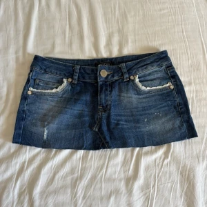 Jeans kjol med spets - Jätte gullig kjol med detaljer. Storlek: XS/S mått: midja rakt över ca 37 cm, längd fram ca 23 cm, något längre bak