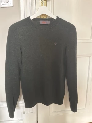 Mörkgrön tröja från Morris - Snygg mörkgrön tröja från Morris med rund halsringning och diskret logobrodyr på bröstet. Tillverkad i mjukt material som känns skönt mot huden. Perfekt till jeans eller chinos för en clean look.
