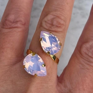 Pear ring Rose Water Opal - Pear Ring, i guldpläterad mässing med kristaller. Pear 14mm kristaller. Färg Rose Water Opal. Ställbar storlek. De sista bilderna visar andra färger och modeller som finns i lager. Jag skickar endast spårbart, samfraktar. Fast pris. Besök gärna mina övriga annonser.  Till mina smycken använder jag kristaller från Preciosa, Aurora och Swarowski.