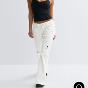 Vita bootcut jeans med slitningar - Skitsnygga och Trendiga vita jeans i bootcut-modell med slitningar på låret och knät med låg midja. Använda en gång!