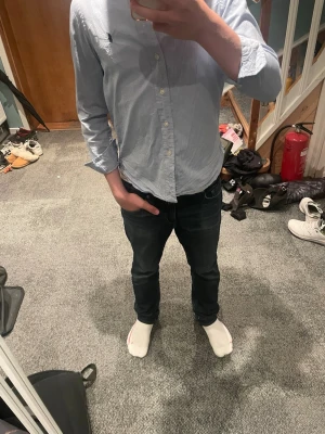 Ljusblå skjorta från Ralph Lauren - Klassisk ljusblå skjorta från Ralph Lauren med knappar framtill och broderad logga på bröstet. Skjortan har lång ärm och normal passform, perfekt till jeans eller ett par schyssta shorts. Tillverkad i bomull för en skön känsla.
