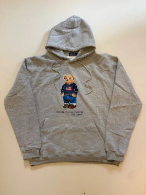 Grå Ralph Lauren hoodie XL - Grå Ralph Lauren polo bear hoodie // 10/10 skick aldrig använd // storlek XL // längd 69cm axelbredd 56cm armlängd 62cm // skriv vid minsta fråga eller fundering🤝