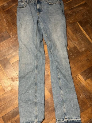 Ljusblå raka jeans - Säljer ett par klassiska ljusblå jeans med rak passform och fem fickor. Jeansen har normal midja och är tillverkade i denim med en snygg tvättad look. Perfekta för en avslappnad stil och passar till det mesta i garderoben.
