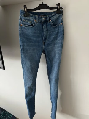 Blå skinny jeans med hög midja - Snygga blå skinny jeans med hög midja och klassisk femficksdesign. 