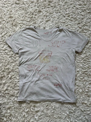 Replay Limited edition | Art collection  - Vit t-shirt från Replays limited edition ”Art collection”- mer än bara en tröja utan konst:  med handritad stil på trycket som föreställer en soppskål och texten 'HOT SOUP'. T-shirten har rund halsringning och korta ärmar. Materialet är mjuk bomull och passformen är normal.