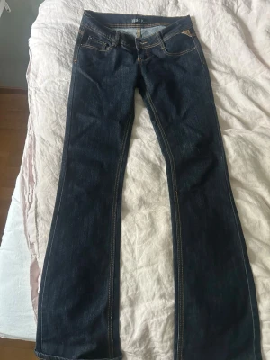 Mörkblå bootcut jeans från Just Y - Snygga mörkblå bootcut jeans från Just Y med klassiska kontrastsömmar och femficksmodell. Jeansen har låg midja och är tillverkade i ett mjukt denimtyg som sitter skönt. 