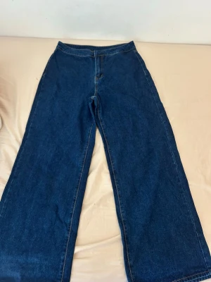 Mörkblå wide leg jeans från SHEIN - Säljer ett par mörkblå wide leg jeans från SHEIN i storlek L. Jeansen har hög midja och raka, vida ben. Materialet är 86% bomull, 8% viskos och 6% polyester. Perfekta för en avslappnad och trendig look.