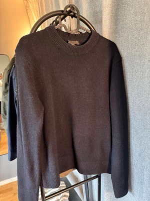 Svart stickad tröja från H&M - Två klassiska stickad tröja, en beige och en mörkblå från H&M med rund halsringning och långa ärmar. Tröjan har en enkel och stilren design med ribbstickade muddar vid ärmslut och nederkant. Perfekt att matcha med jeans eller kjol. NY PRIS PER ST 699kr