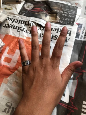 Silverfärgad ring med rosdetalj - Säljer en stilren silverfärgad ring med en snygg rosdetalj framtill. Ringen har en klassisk, rund form och passar perfekt för dig som gillar unika accessoarer med lite edge. Materialet ser ut att vara metall och designen är enkel men ändå iögonfallande.