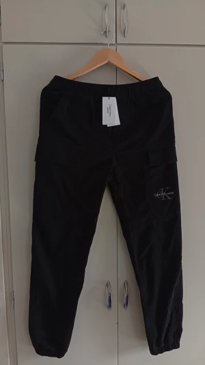 Svarta cargobyxor Calvin Klein  - Helt nya svarta cargobyxor från Calvin Klein. Byxorna är i nyskick orginal lappar och allt finns kvar vilket syns bättre på tredje bilden hör av dig vid funderingar 