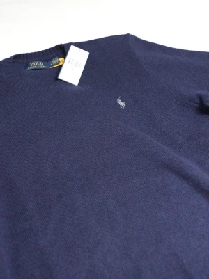 POLO RALPH LAUREN - Cashmere Hunternavy Crewneck - Mörkblå stickad tröja från Polo Ralph Lauren med rund halsringning och klassisk broderad logga på bröstet. Nypris 2695, säljes då den ej passar längre. Mycket gott skick, inget synligt slitage eller dylikt. https://www.ralphlauren.se/en/wool-cashmere-crewneck-jumper-633819.html