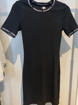 Svart kortärmad klänning  - En svart T-shirt klänning från H&M, storlek S.