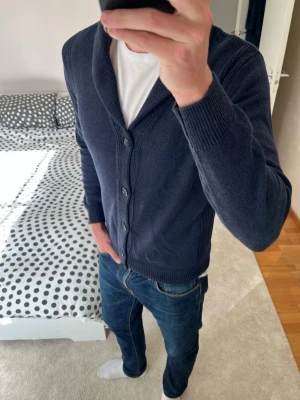 Mörkblå cardigan från Massimo Dutti - Säljer en väldigt snygg mörkblå cardigan från Massimo Dutti i ett väldigt fint skick! Cardiganen är i storleken M och tillverkad i cashmere och bomull! ✌🏼😊——————————————————————————                                                                      📐| Storlek: M                                                           👖| Märke: Massimo Dutti                                     🔎| Skick: Mycket Fint!                                                     ✍🏻| Skriv vid frågor